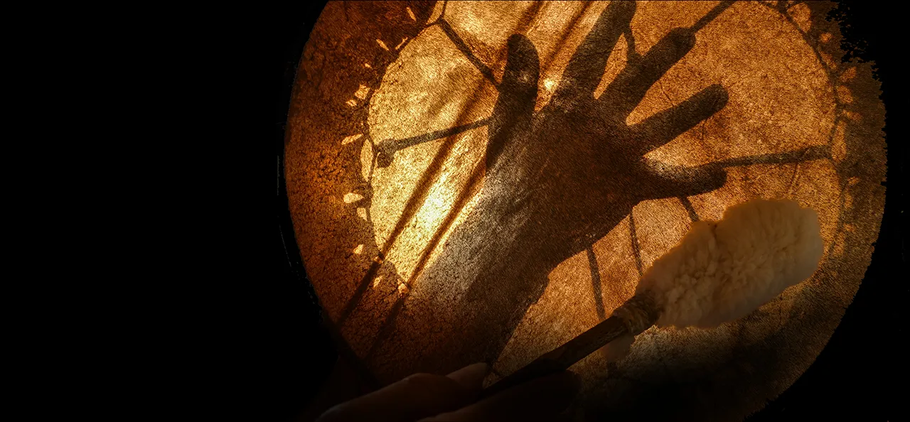 Der Schatten einer Hand unter einer von unten beleuchteten Trommel